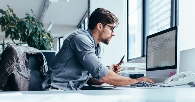 Person working at a laptop computer. The choice to upgrade or repair technology is one business owners struggle with.